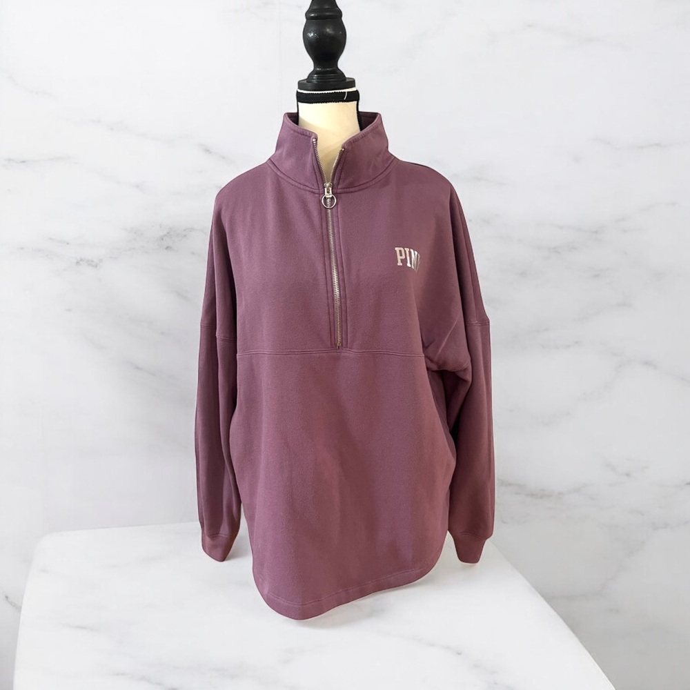A mauve quarter-zip sweatshirt with a relaxed fit and high collar.
